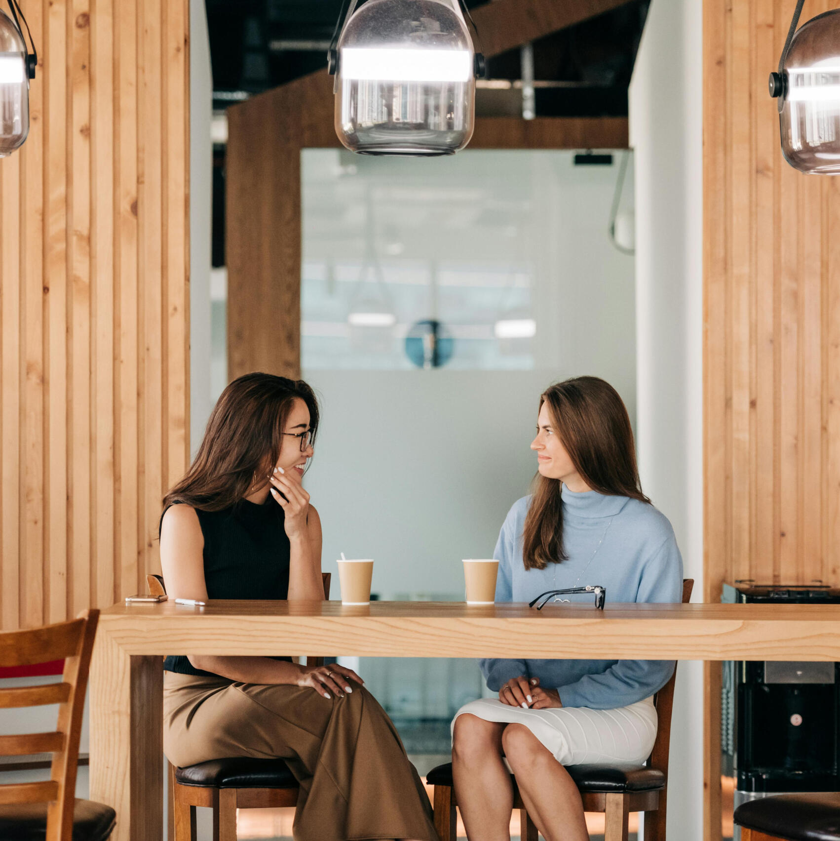 Become a Featured Educator Two women chatting over coffee.